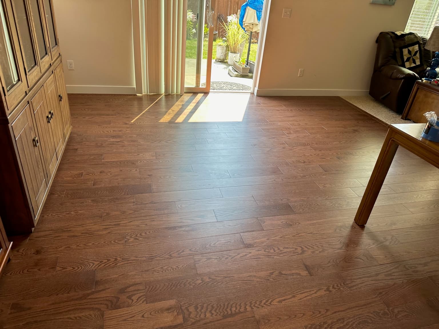 Stained oak hardwood flooring installed through a living and dining room by Best Pro Contractors